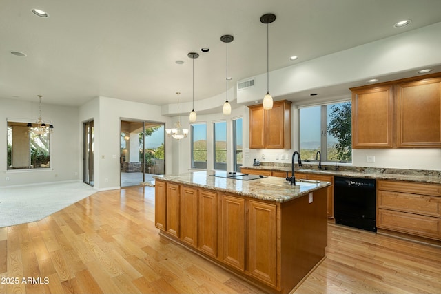 kitchen featuring black appliances, an island with sink, a chandelier, and pendant lighting