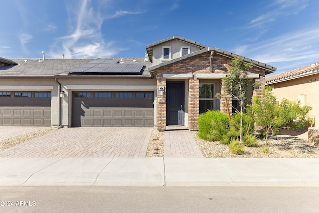 view of front facade featuring a garage and solar panels