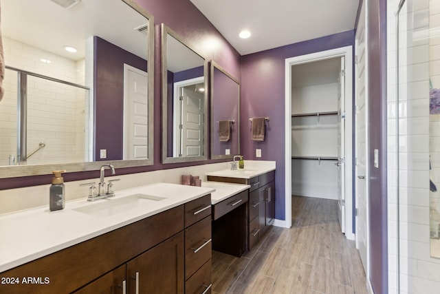 bathroom with a shower with door and vanity