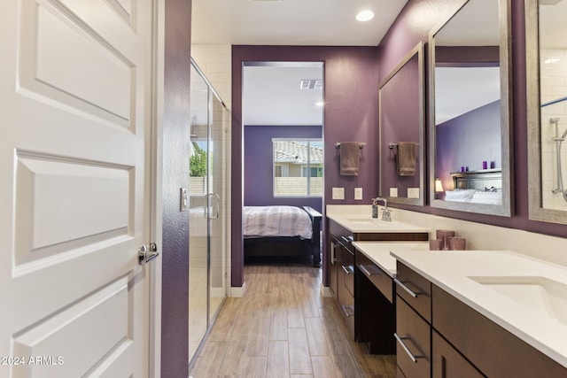 bathroom featuring a shower with door, hardwood / wood-style floors, and vanity