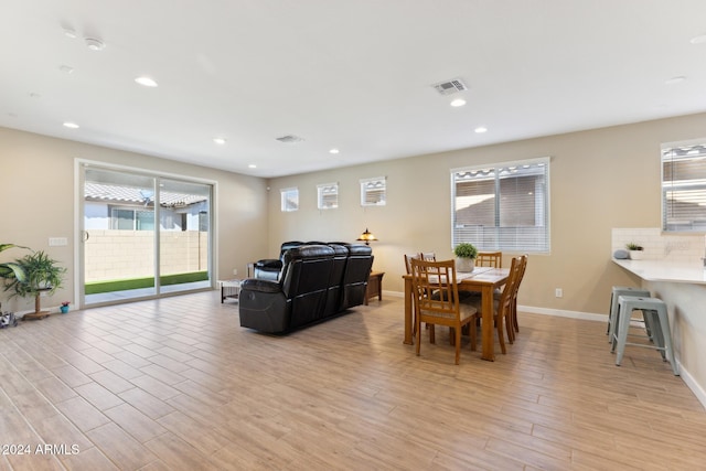 dining space with light wood-type flooring and plenty of natural light