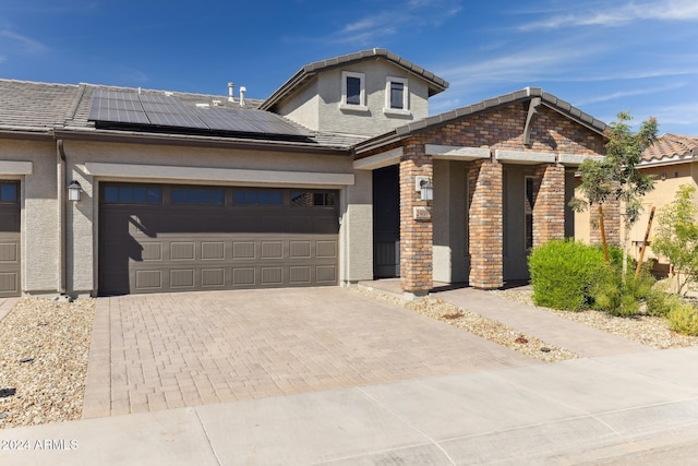 view of front of house with a garage and solar panels