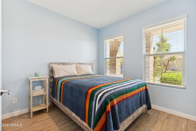 bedroom with hardwood / wood-style floors and multiple windows