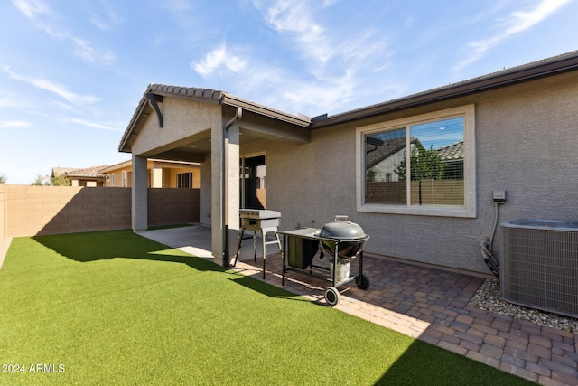 rear view of house with a patio, a lawn, and central AC unit