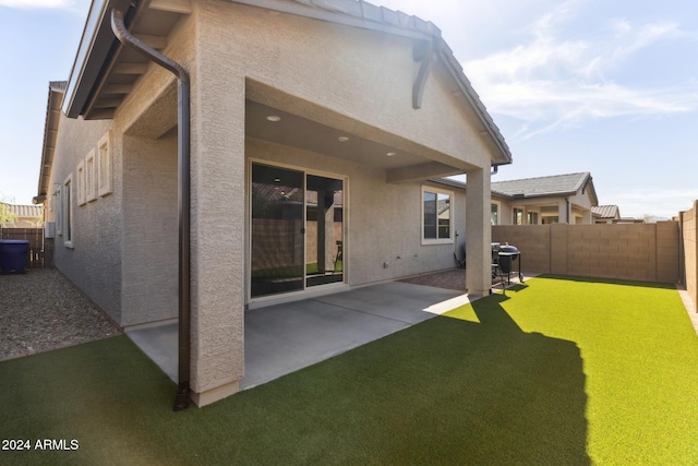 rear view of property featuring a yard and a patio area