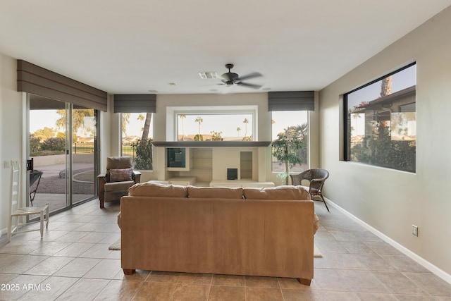 living room featuring a wealth of natural light, ceiling fan, and light tile patterned floors