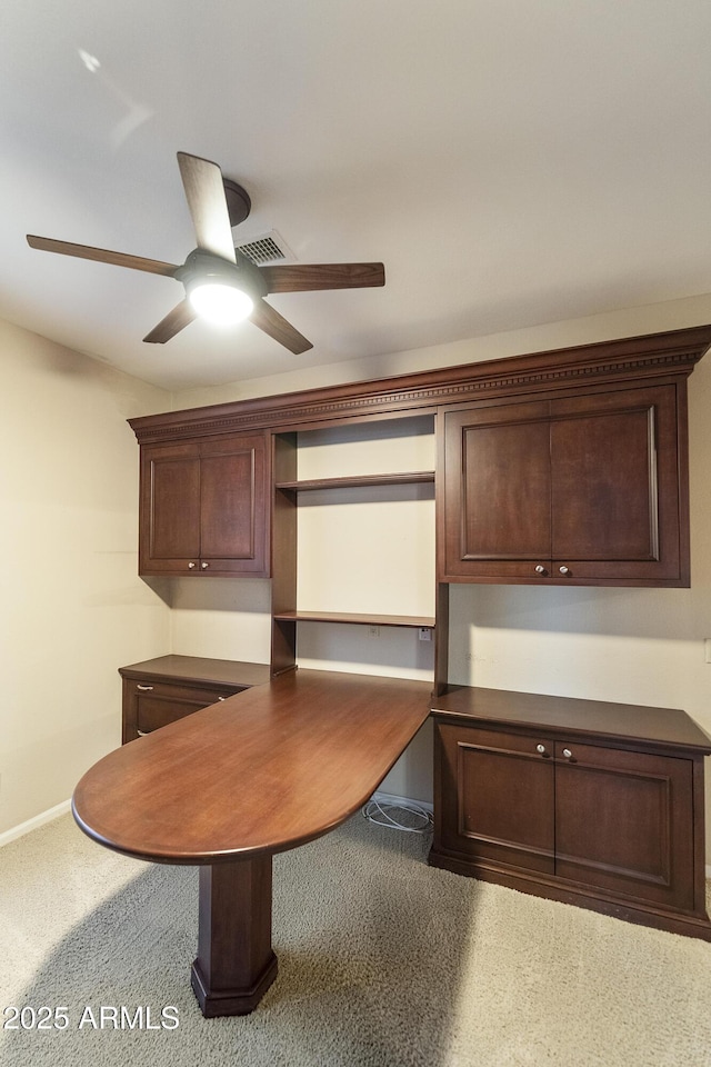 kitchen featuring dark brown cabinets, built in desk, and ceiling fan