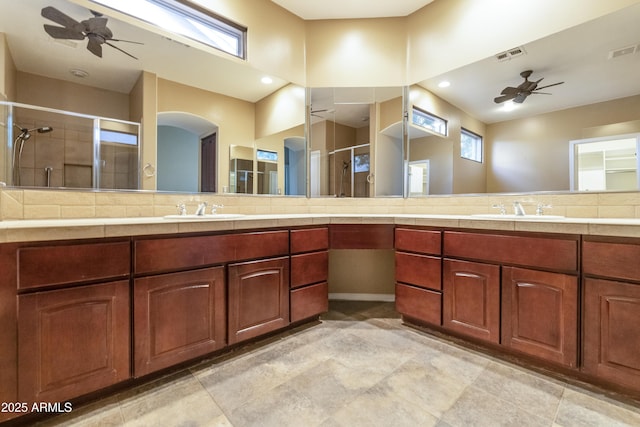 bathroom with vanity, ceiling fan, and a shower with shower door