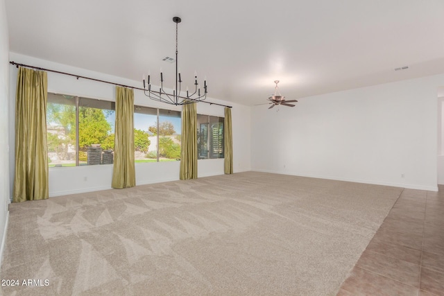 carpeted spare room with ceiling fan with notable chandelier