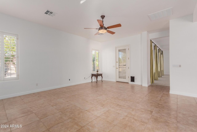 tiled empty room featuring ceiling fan