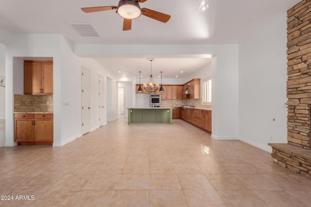 unfurnished living room with ceiling fan with notable chandelier and light tile patterned flooring