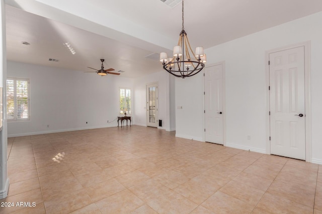 tiled empty room with ceiling fan with notable chandelier