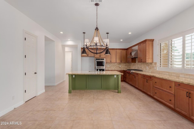 kitchen featuring a center island, wall chimney range hood, pendant lighting, light tile patterned floors, and appliances with stainless steel finishes