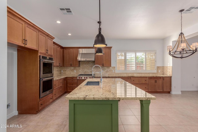 kitchen featuring pendant lighting, an island with sink, an inviting chandelier, and wall chimney range hood