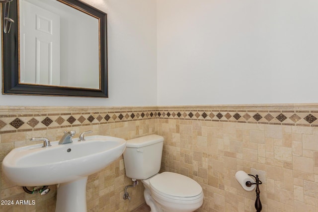 bathroom featuring toilet and tile walls