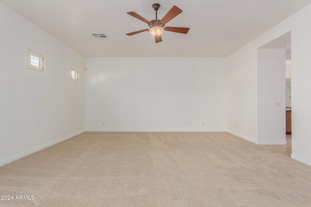 spare room with ceiling fan and light carpet