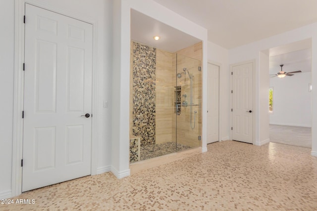 bathroom featuring ceiling fan and an enclosed shower