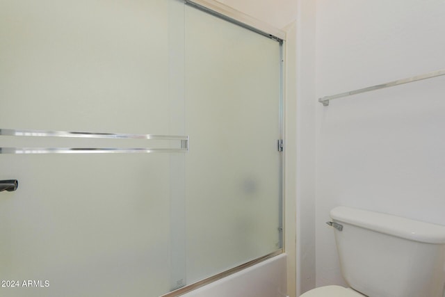 bathroom with enclosed tub / shower combo and toilet