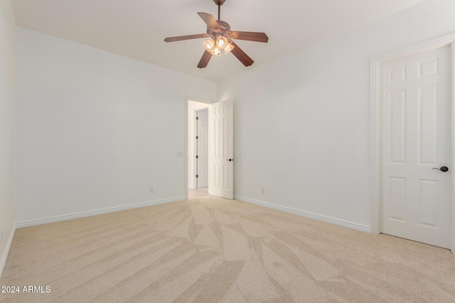 spare room with ceiling fan and light carpet