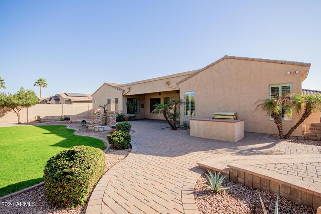 rear view of property with a yard and a patio