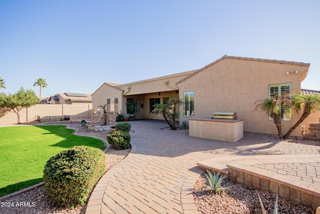 rear view of house with a yard and a patio