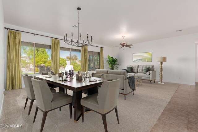 tiled dining space featuring ceiling fan with notable chandelier