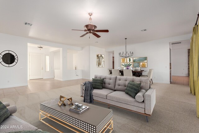 carpeted living room featuring ceiling fan with notable chandelier