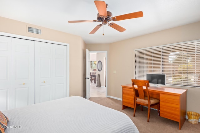 bedroom with light carpet, ceiling fan, and a closet