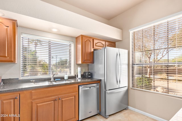 kitchen with a healthy amount of sunlight, stainless steel appliances, sink, and light tile patterned floors