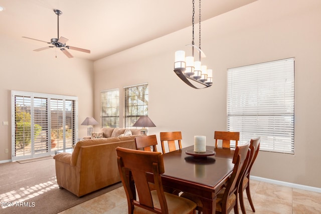 dining room with light tile patterned flooring and ceiling fan with notable chandelier