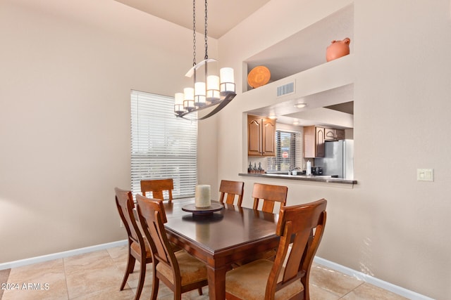 tiled dining room featuring an inviting chandelier