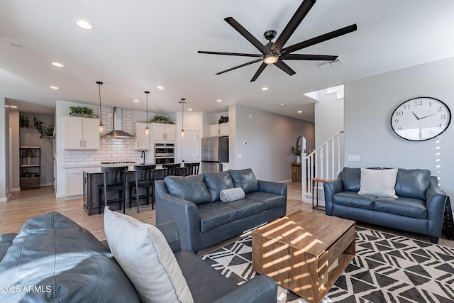 living room with ceiling fan and light hardwood / wood-style floors