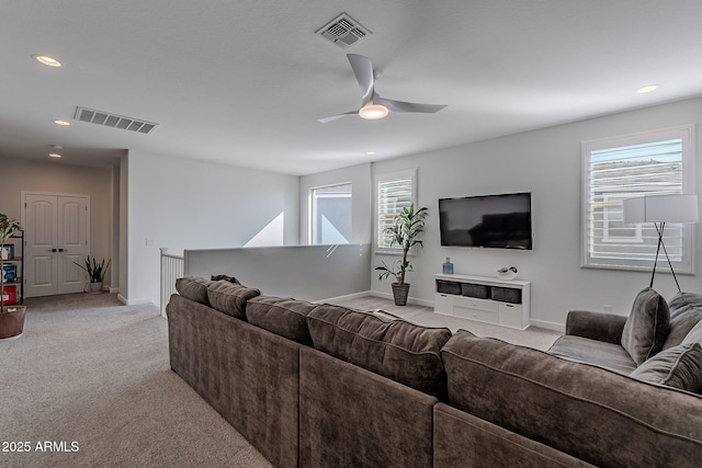 carpeted living room with ceiling fan