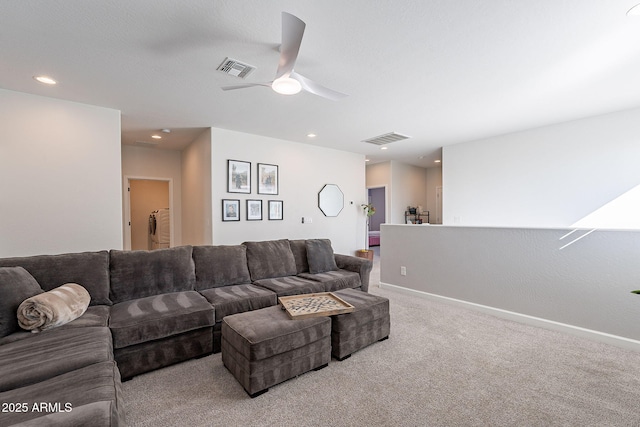 living room featuring washer / dryer, light colored carpet, and ceiling fan