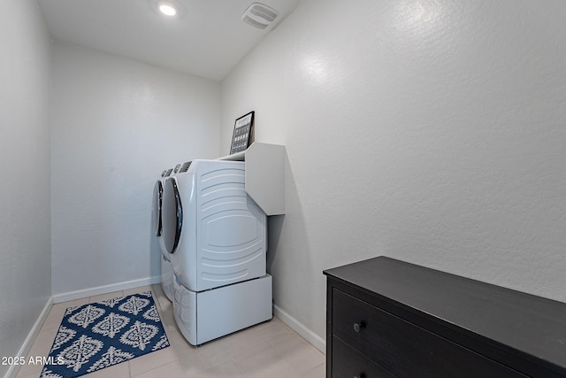 laundry room with washing machine and dryer and light tile patterned floors