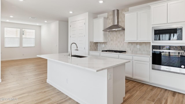 7327 W Buckhorn Trl, Peoria, AZ 85383 - kitchen with oven, wall chimney exhaust hood, gas stovetop, built in microwave, and light wood-type flooring
