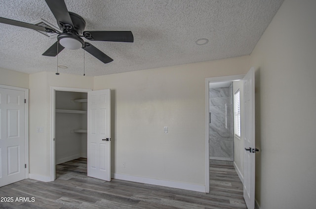 unfurnished bedroom featuring ceiling fan, a closet, a textured ceiling, and light wood-type flooring