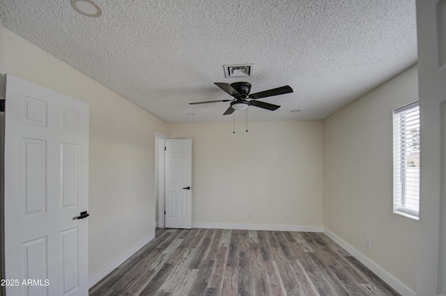 unfurnished room with ceiling fan, wood-type flooring, and a textured ceiling