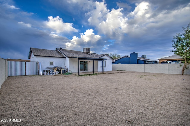 rear view of house with a patio area and central AC