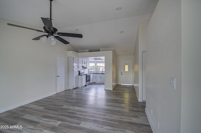 unfurnished living room with hardwood / wood-style floors, ceiling fan, and vaulted ceiling