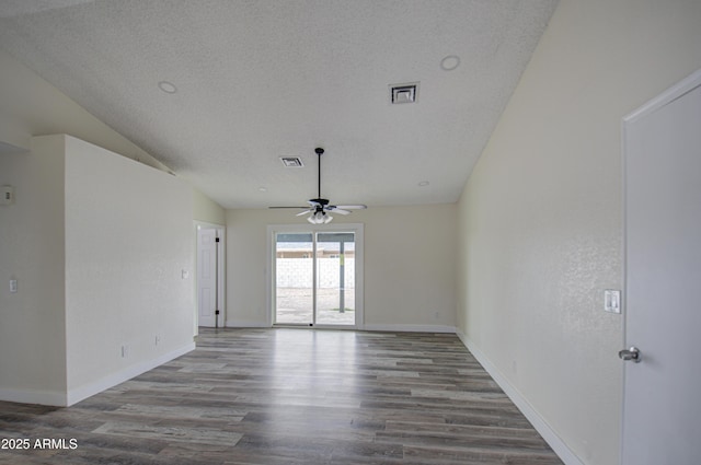 spare room featuring lofted ceiling, ceiling fan, wood-type flooring, and a textured ceiling