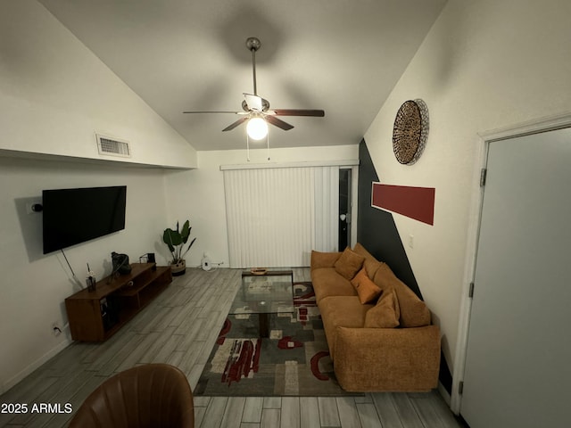 living room with ceiling fan, lofted ceiling, and light wood-type flooring