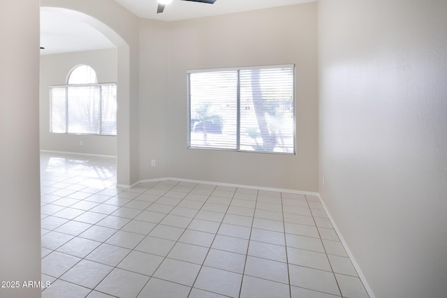 tiled spare room with ceiling fan