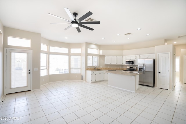 kitchen featuring light tile patterned flooring, stainless steel appliances, sink, and white cabinets