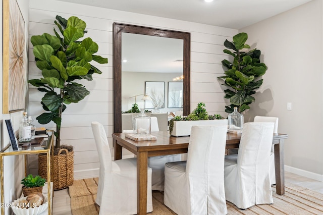 dining room featuring light hardwood / wood-style floors and wood walls