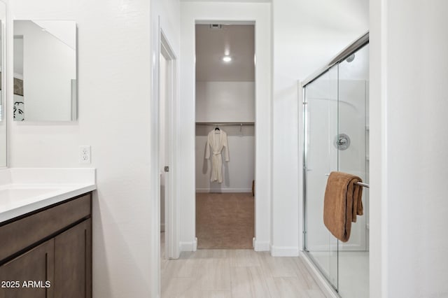 bathroom with vanity and a shower with shower door