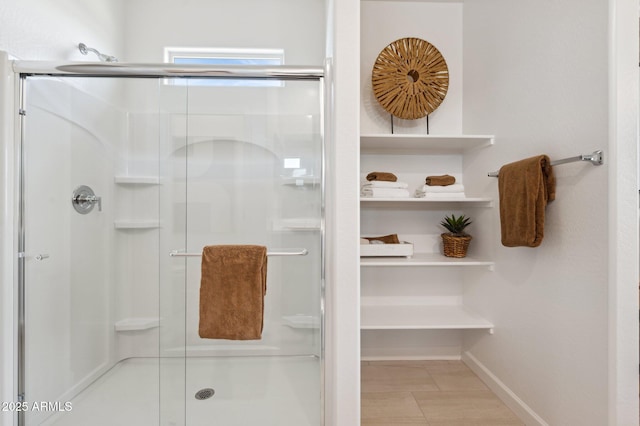 bathroom featuring a shower with shower door