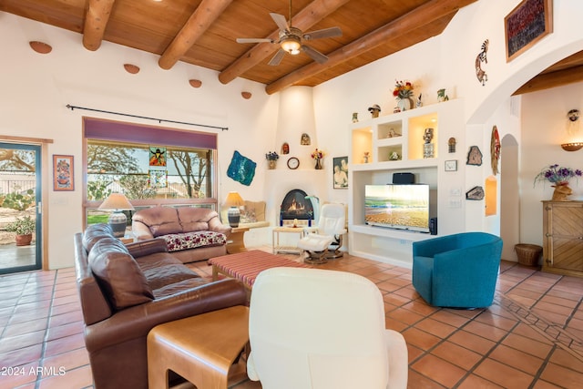 living room with beamed ceiling, a large fireplace, tile patterned flooring, and wooden ceiling