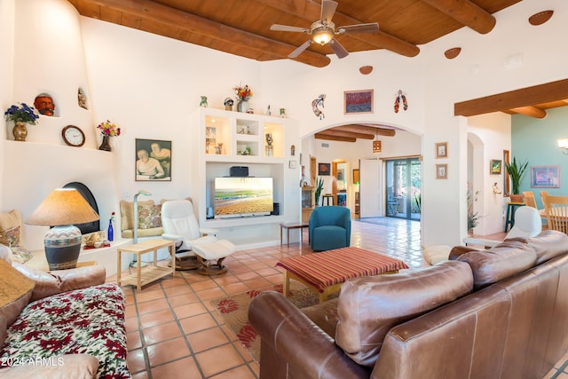 tiled living room with beamed ceiling, ceiling fan, a high ceiling, and wood ceiling