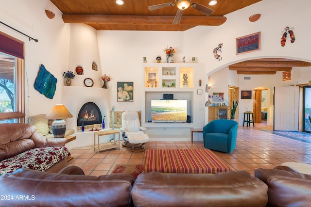 living room featuring tile patterned flooring, wood ceiling, a large fireplace, and beamed ceiling